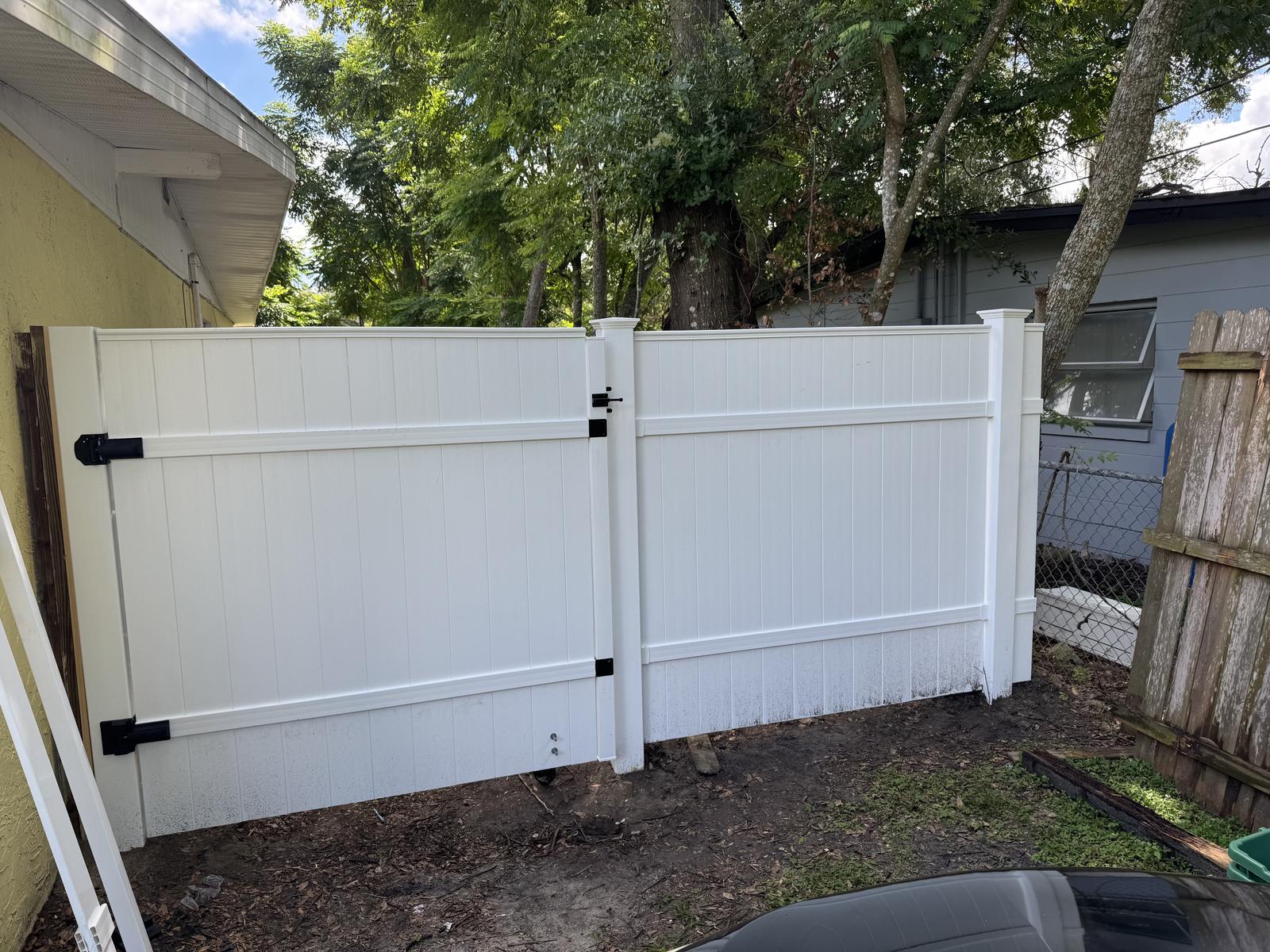 Finished white vinyl privacy fence with a matching gate