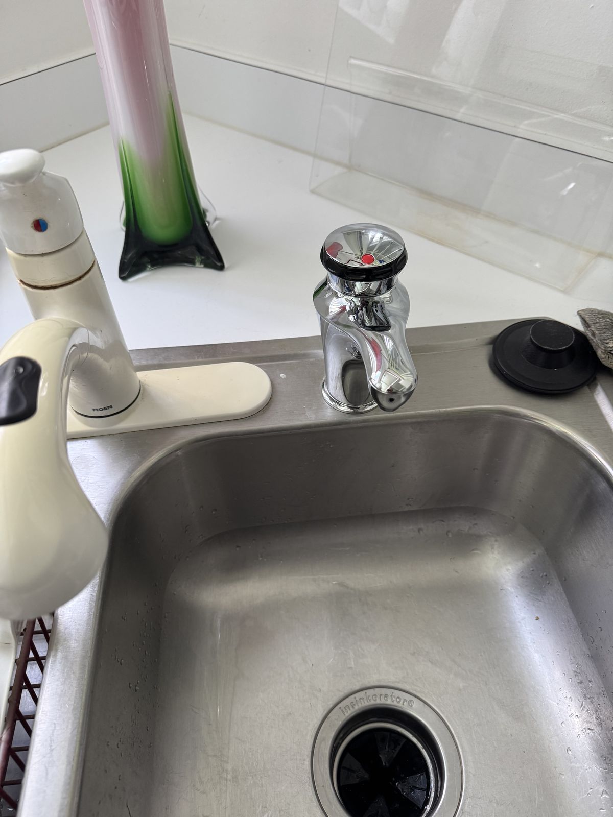 Chrome instant hot water dispenser at a stainless kitchen sink